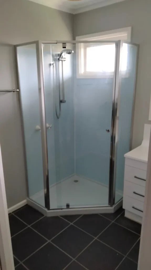 Framed corner glass shower screen with a hinged door