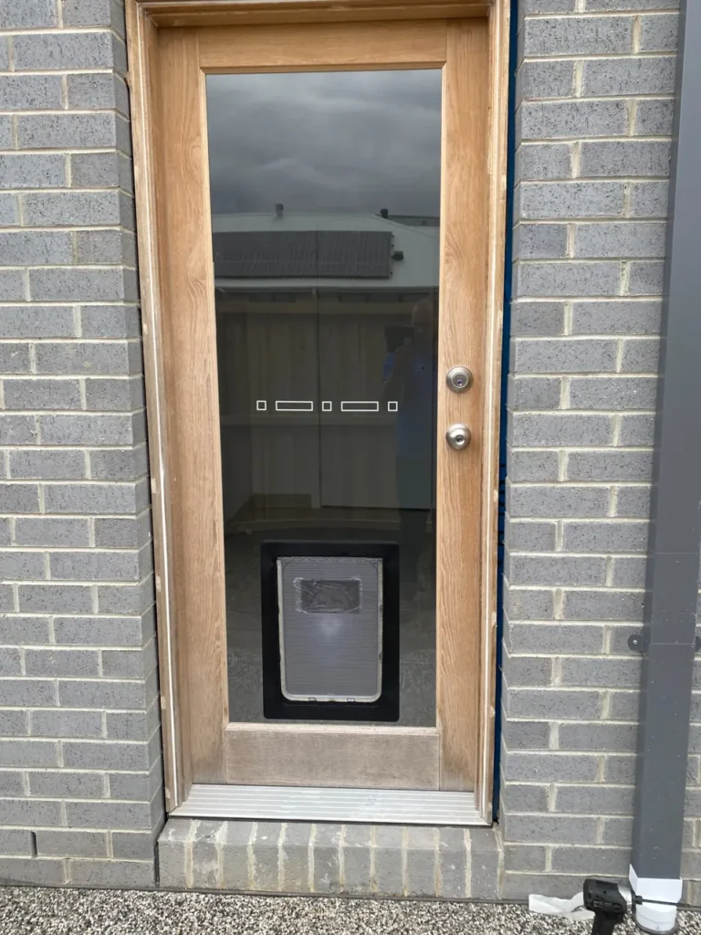 Pet door installed in a glass panel within a timber door
