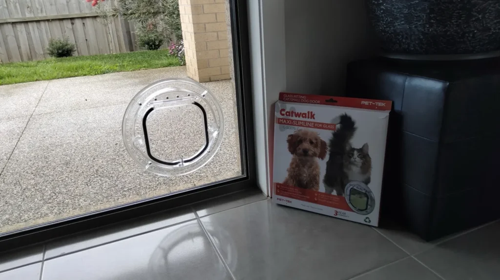 Pet door fitted into a glass panel beside a sliding door