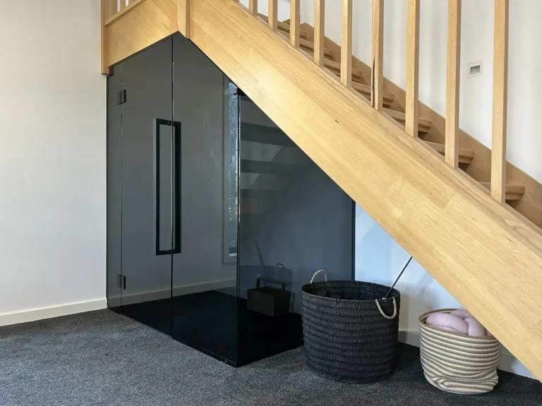 Custom grey glass enclosure beneath a timber staircase